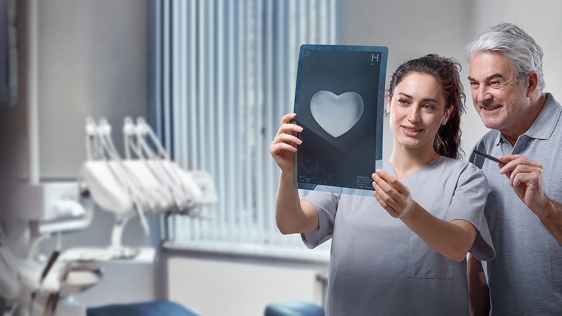Zwei Zahnarzte schauen sich ein Roentgen Herz an